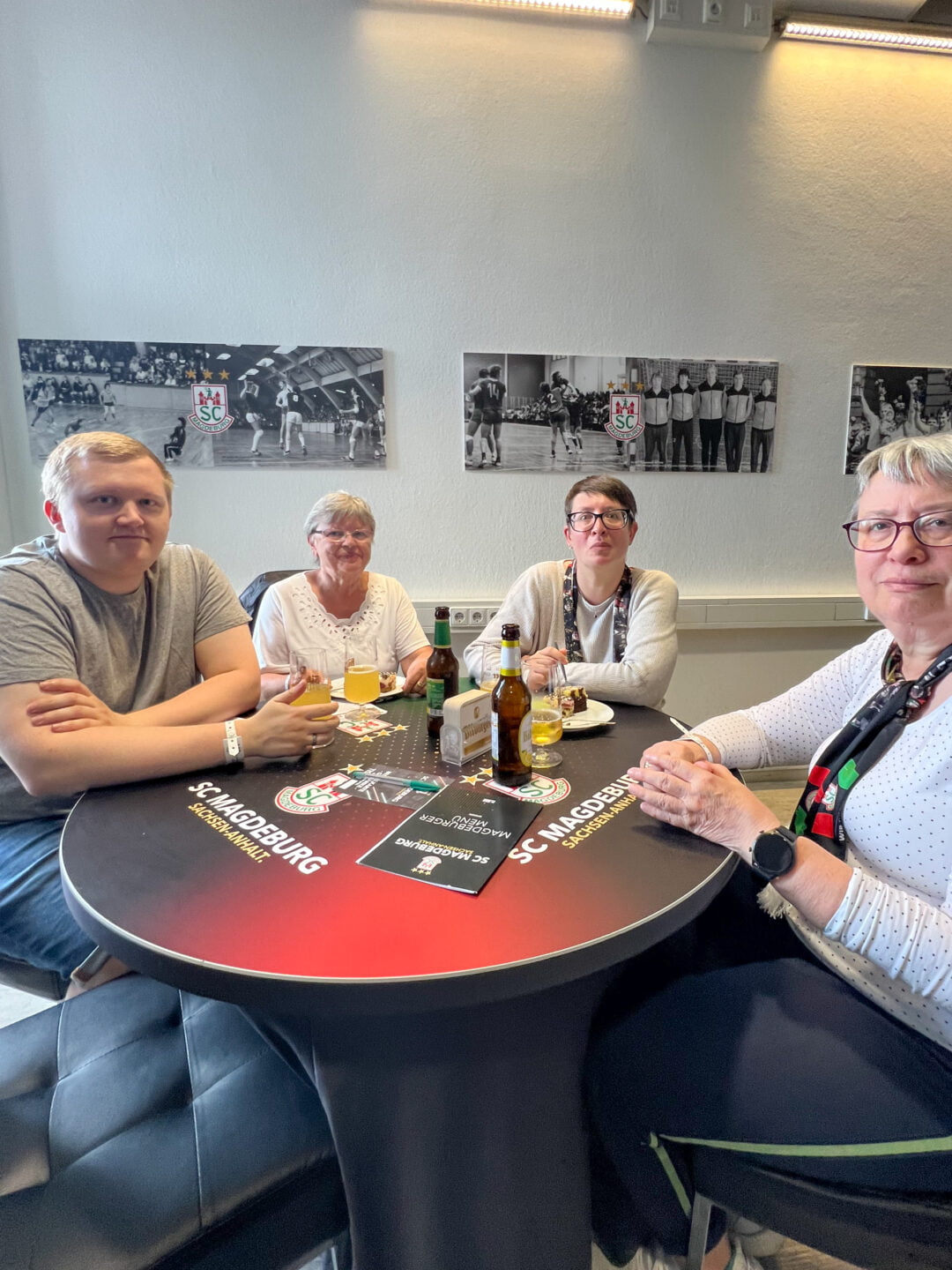 4 Personen an einem Tisch in der Klaus-Miesner-Lounge der GETEC Arena, die freundlich in die Kamera schauen.