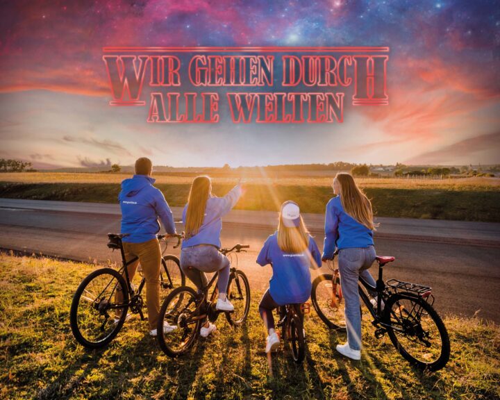 Vier junge Erwachsene auf Fahrrädern am Horizont im Sonnenuntergang. Azubikampagne 2023 der Wohnungsbaugenossenschaft Otto von Guericke eG