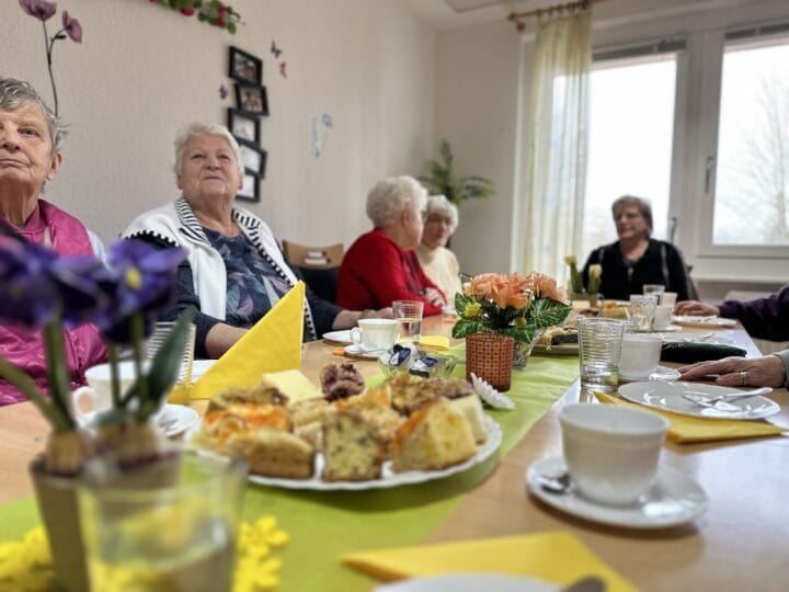 Senioren gemeinsam an einem Tisch bei Kaffee und Kuchen