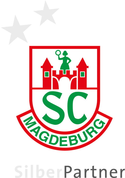 Das rot grüne Vereinslogo des SC Magdeburgs mit zwei silbernen Sternen darüber. Auf dem Logo ist eine Frau zu erkennen, welche auf einer Burg steht. Da drunter steht Silber Partner.